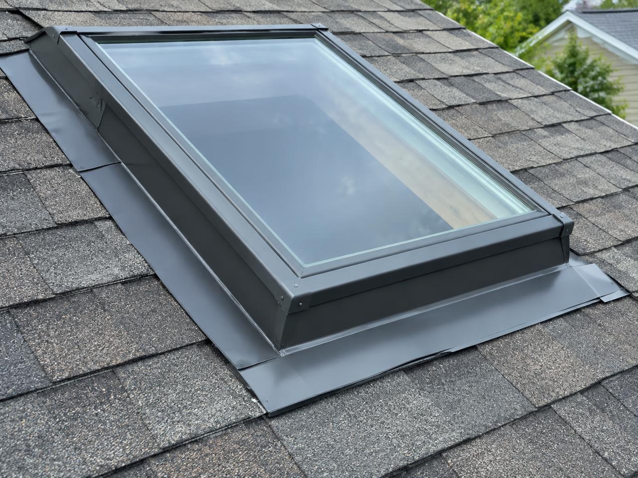Skylight on a shingle roof with new metal flashing sealed around it